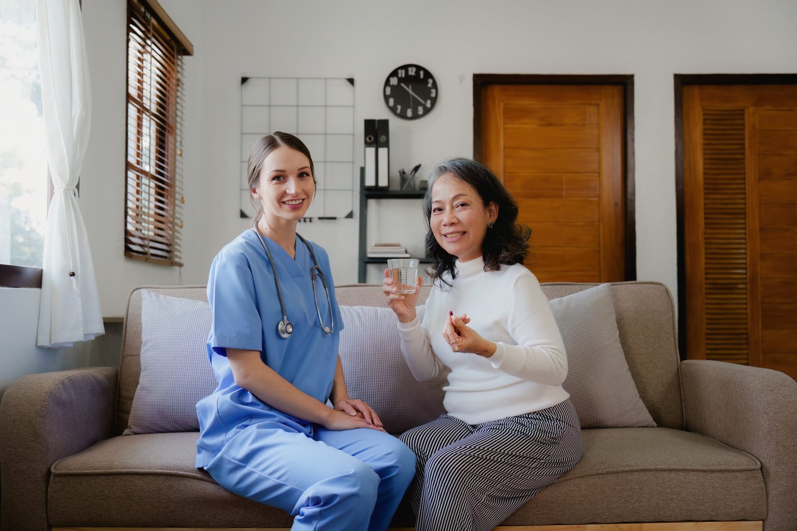 Woman provides dementia home care services by assisting her customers in taking their medication.